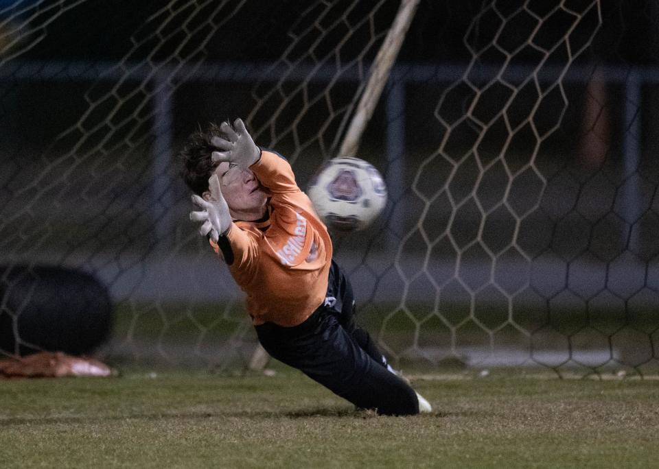 Goalkeeper Ethan Koivu (0) dives to redirect the ball to make a save on a penalty kick by (10) during the Booker T. Washington vs Gulf Breeze boys soccer game at Gulf Breeze High School on Thursday, Jan. 11, 2024.