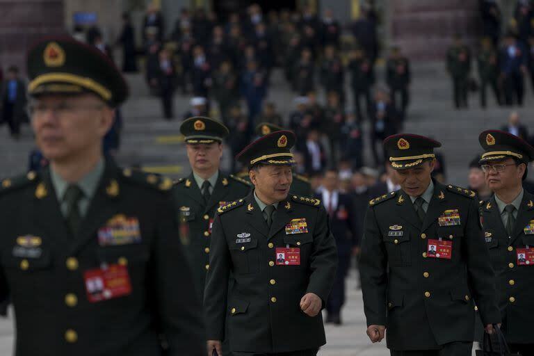 Chinese military officers leave the Great Hall of the People after attending a preparatory session of the National People's Congress (NPC) in Beijing, Monday, March 4, 2024. 