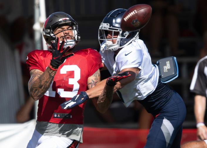 Tampa Bay Buccaneers wide receiver Mike Evans (13) pulls in a catch over Tennessee Titans cornerback Caleb Farley (3) during a joint training camp practice at AdventHealth Training Center Thursday, Aug. 19, 2021 in Tampa, Fla.  