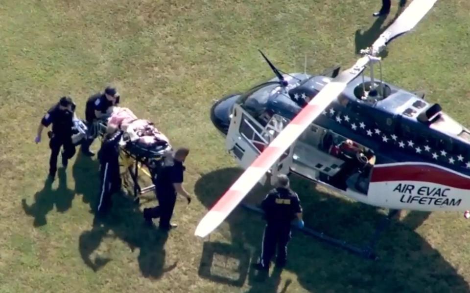 Paramedics rush one of the injured to an air ambulance