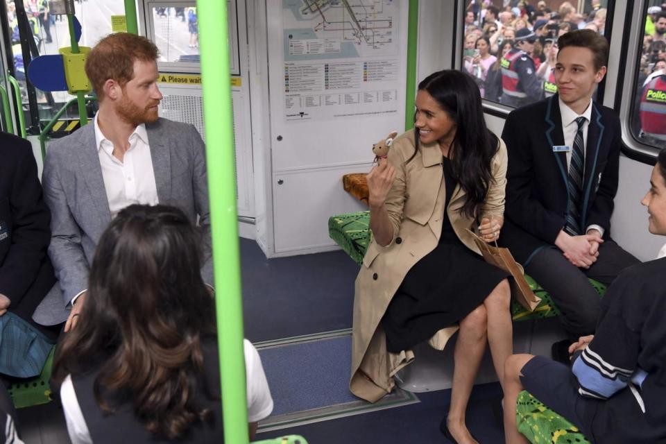 Britain's Prince Harry and his wife Meghan, Duchess of Sussex chat with local schoolchildren as they take a ride on a tram in Melbourne (AFP/Getty Images)