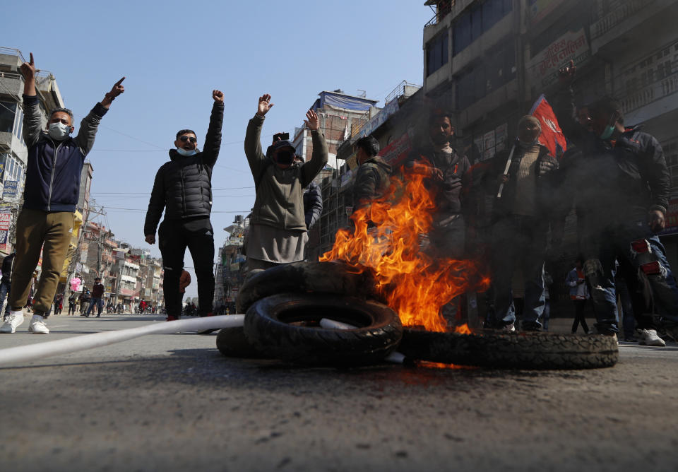 Nepalese demonstrators burn tires and chant slogans during a general strike in Kathmandu, Nepal, Thursday, Feb. 4, 2021. A general strike called by a splinter faction of the ruling Communist party paralyzed life in Nepal on Thursday, shutting down schools, transportation and markets. Highways were deserted and shops were closed by the strike protesting Prime Minister Khadga Prasad Oli's decision to dissolve Parliament and call new elections. (AP Photo/Niranjan Shrestha)