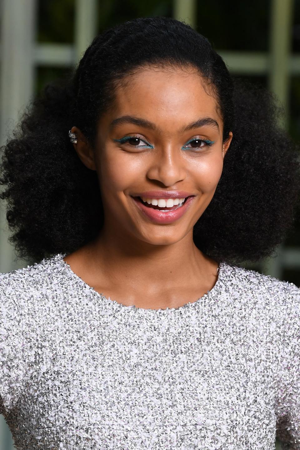 At the Spring/Summer 2018 Chanel Couture show, Yara opted for her signature fresh faced look, adding a bit of green eyeliner for a fun spin on her usual cat eye. With her hair pulled back to show off her face, she added a sheer pink shade to her lips for a colorful vibe.