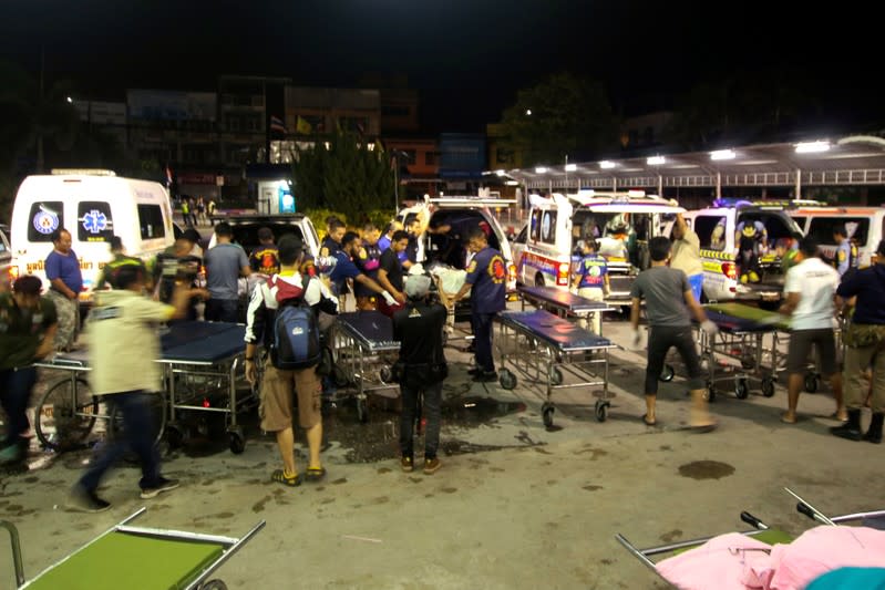 Rescue workers transfer the bodies of dead village defence volunteers, who were killed by suspected separatist insurgents, to stretcher trolleys at a hospital in Yala province