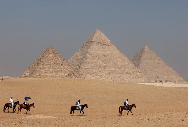 FILE PHOTO: Tourists ride horses in front of the Great Pyramid of Giza