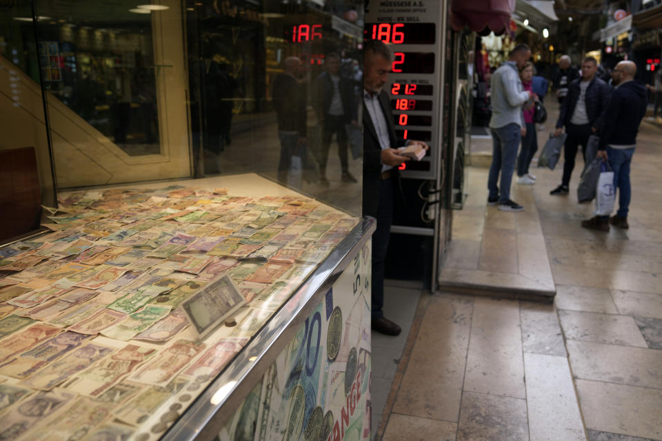 A man holds bank notes as he leaves a currency exchange shop in Istanbul, Turkey, Friday, Oct. 14, 2022. As the value of the U.S. dollar soars, other currencies around the world are sinking by comparison. (AP Photo/Khalil Hamra)