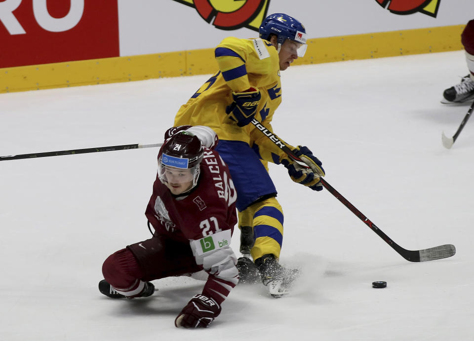 Latvia's Rudolfs Balcers, left, checks Sweden's Jesper Bratt during the Ice Hockey World Championships group B match between Sweden and Latvia at the Ondrej Nepela Arena in Bratislava, Slovakia, Monday, May 20, 2019. (AP Photo/Ronald Zak)