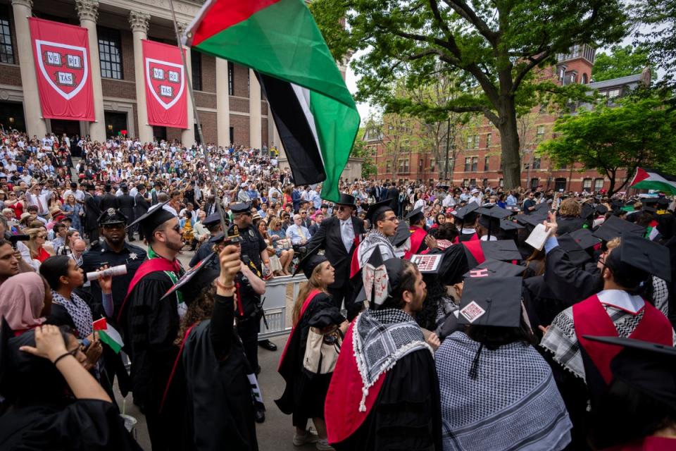 Graduating students hold Palestinian flags and chant as they walk out in protest over the 13 students who have been barred from graduating due to protest activities, during commencement in Harvard Yard (AP)