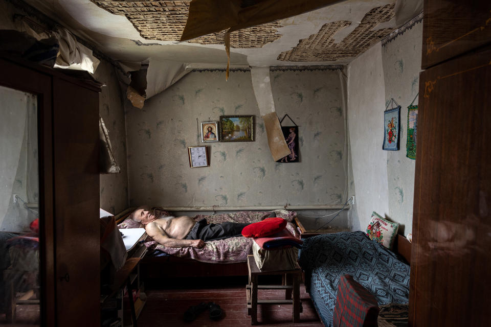 Olexiy Pshenychnykh, 85, rests in his war-damaged home to the east of Kharkiv in Vilkhivka, Ukraine, on May 18, 2022. Older people in the city have been relying on humanitarian aid, as their monthly government pension payments were suspended because of the fighting.