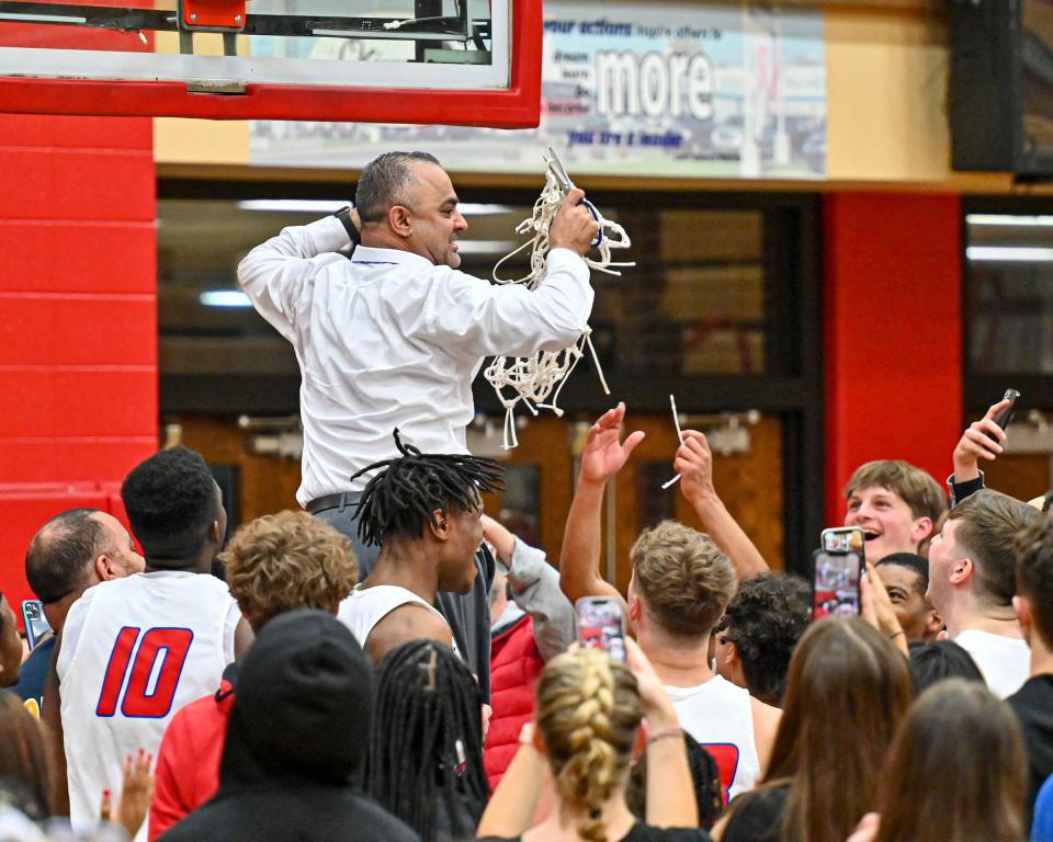 Adams head coach Chad Johnston cuts down the net after Adams defeated Michigan City in the the 4A Sectional finals Saturday, March 5, 2022, at Plymouth High School.