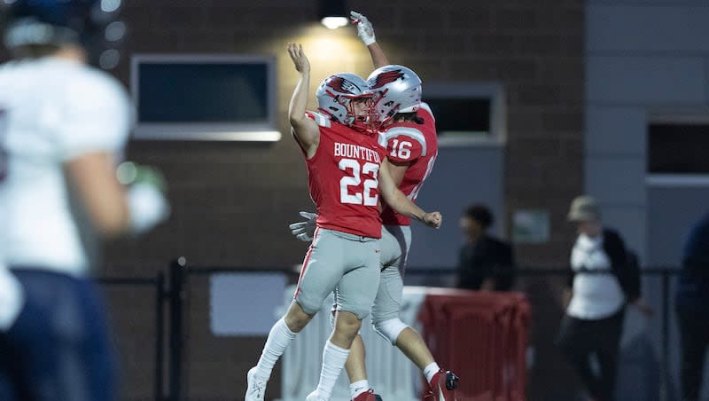 Bountiful's Blake Bauer (16) and Landon Zayas (22) celebrate a touchdown by Bauer during a game against Herriman at Bountiful High School in Bountiful on Friday, Aug. 16, 2024.