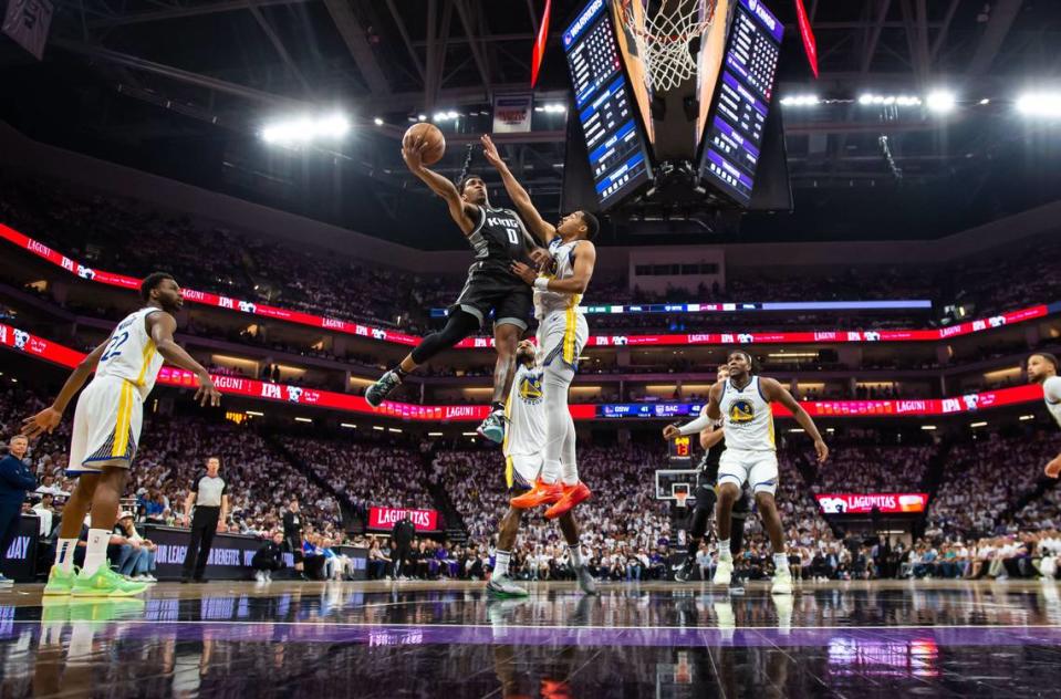 Sacramento Kings guard Malik Monk (0) goes up for a shot as Golden State Warriors guard Jordan Poole (3) defends during the first half of the first-round NBA basketball playoff series at Golden 1 Center on Saturday, April 15, 2023.