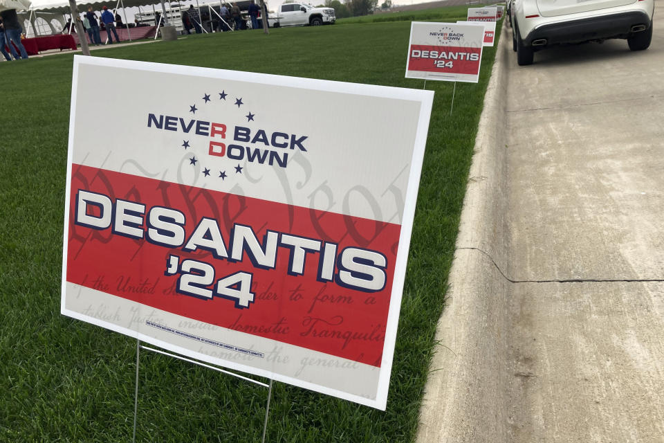 Yard signs promoting Florida Gov. Ron DeSantis in 2024, financed by the super PAC promoting DeSantis for president, line the street leading up to a Republican congressional fundraiser on May 13. 2023, in Sioux Center, Iowa. The super PAC, Never Back Down, is taking on the labor-intensive task of organizing support in the 2024 Iowa caucuses for DeSantis, though barred by law from coordinating with the candidate. (AP Photo/Tom Beaumont)