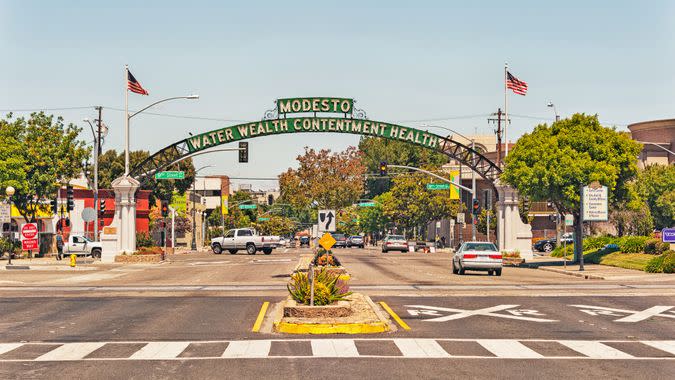 Modesto, California, USA - May 15, 2016: This Arch with the name and mottos of the City Welcomes visitors to Modesto in the Central Valley of Northern California, the arch defines the feelings of the population that enjoys calling this home, the many signs and flags and vehicles make this entrance to this sections of this city very interesting and within close distance of historic site and museum this is also the setting for a very classic movie American Graffiti, areas of the city reflect the memories of the 1950's and on this May day it was very comfortable and interesting.