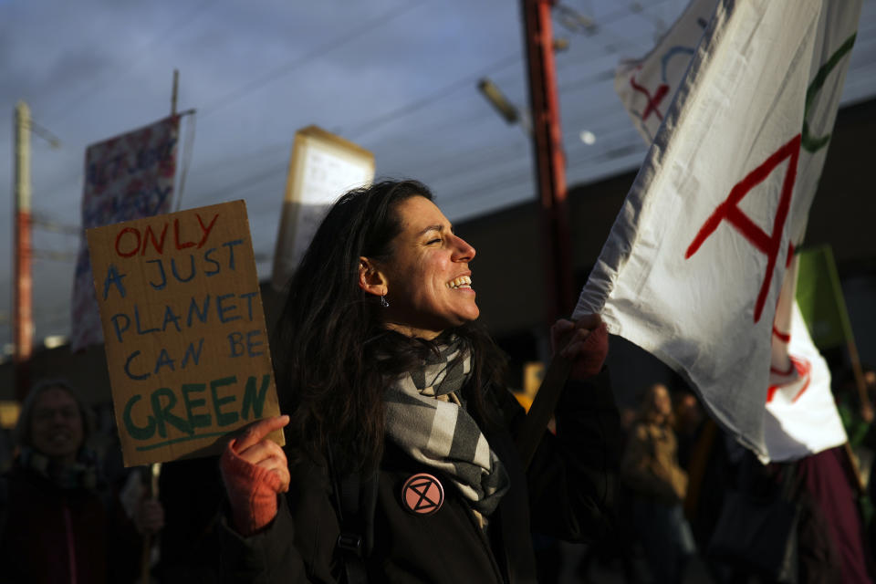 A woman shouts slogans as she marches with others during a worldwide protest demanding action on climate change in Brussels, Friday, Nov. 29, 2019. (AP Photo/Francisco Seco)