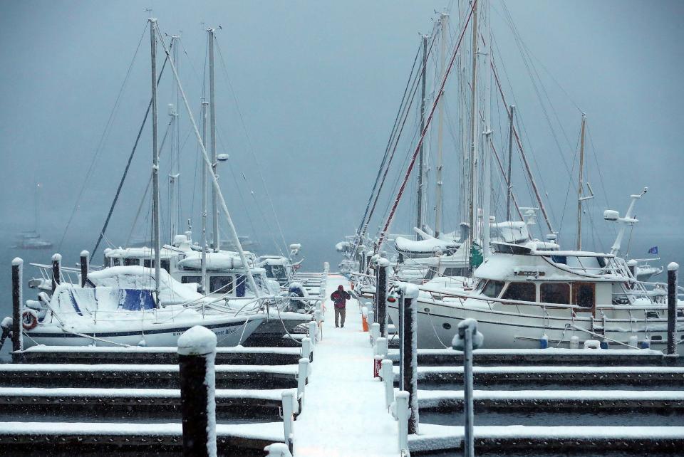 Christopher Burgess walks down the snowy dock at the Poulsbo Marina on Tuesday.