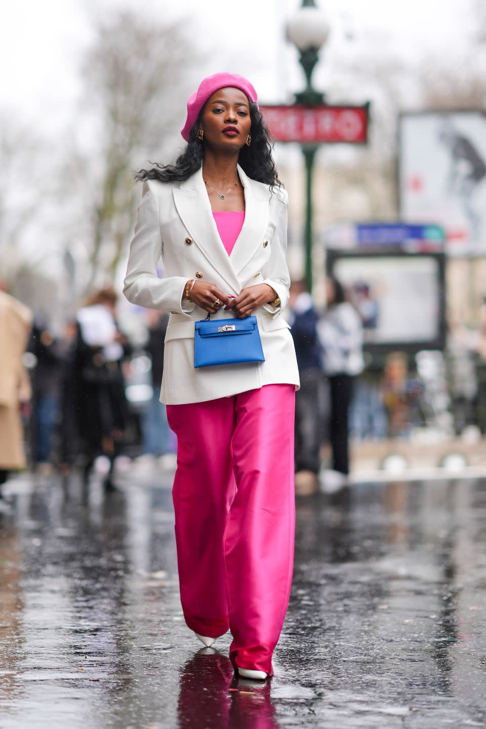 paris, france march 02 a guest wears a pink beret hat, a pink low neck top, a white blazer jacket, pink shiny pants, white pointed shoes, a blue leather bag, outside hermes, during the womenswear fallwinter 20242025 as part of paris fashion week on march 02, 2024 in paris, france photo by edward berthelotgetty images