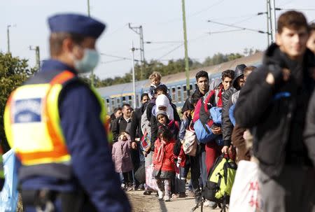 Migrants queue to board a train at the railway station in Zakany, Hungary October 1, 2015. REUTERS/Bernadett Szabo