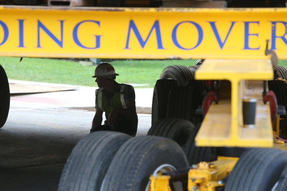 Workers begin moving the May house Thursday from Park Lane to its new location at 919 Riverside Drive in South Bend. A worker crouches under the house to endure all is well during the move.