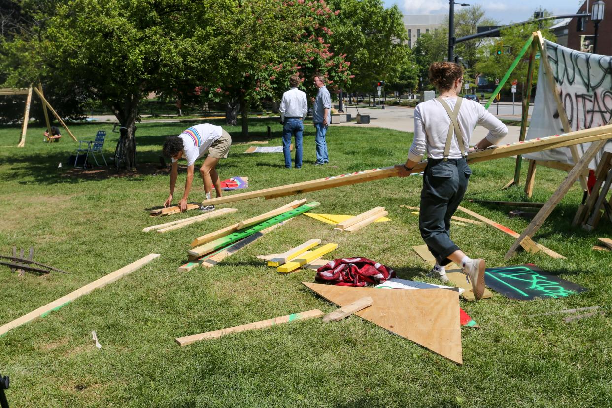 Protestors work on taking down the wooden structures built during the encampment protest, Monday, May 6, 2024, at Purdue University Memorial Mall in West Lafayette, Ind.