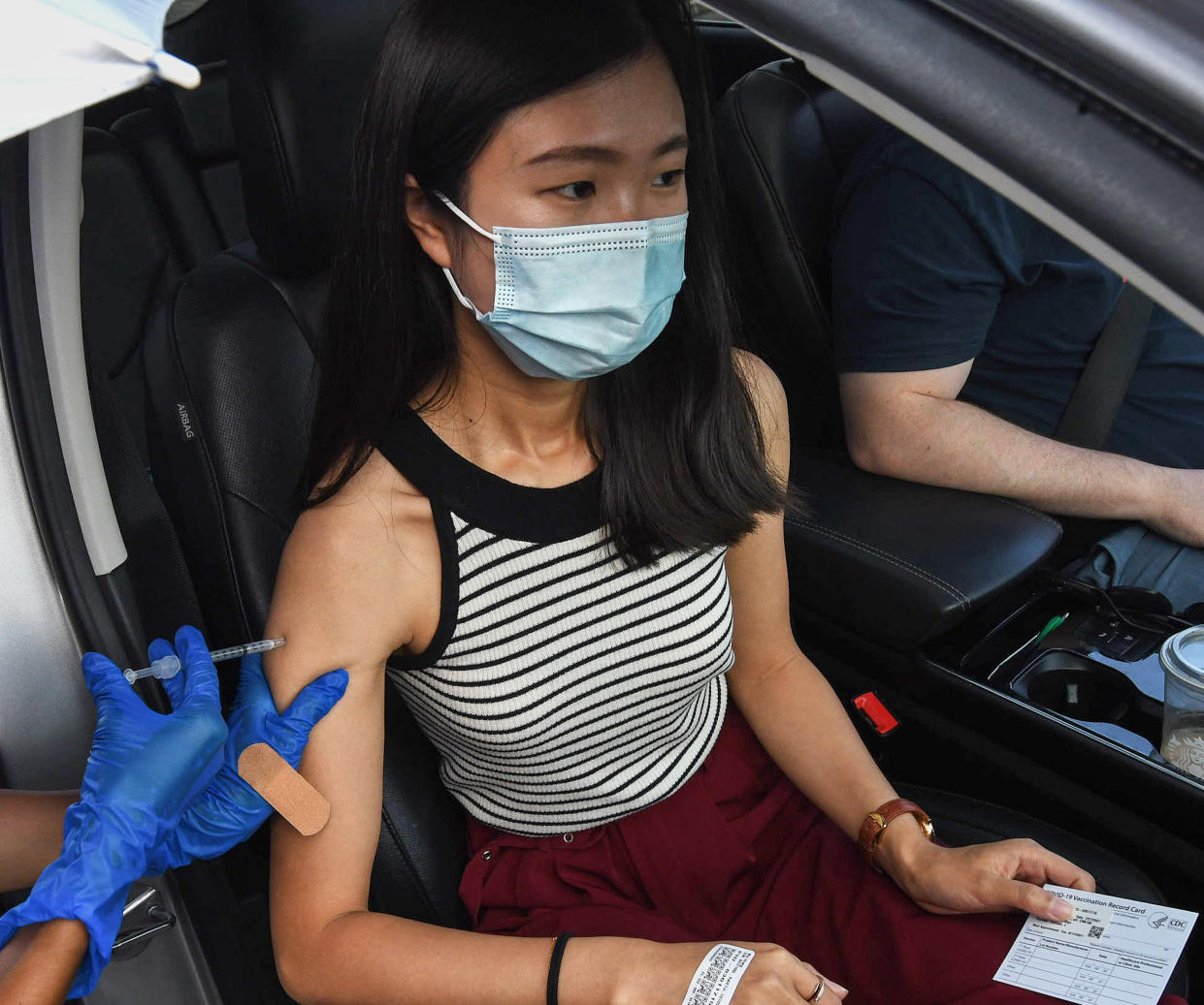 ORLANDO, UNITED STATES - 2021/07/27: Min Huang receives a shot of COVID-19 vaccine at a drive-thru vaccination and testing site at Barnett Park in Orlando. 
Coronavirus cases in Orange County are currently reaching approximately 1,000 cases a day due to the Delta variant and high numbers of unvaccinated residents. (Photo by Paul Hennessy/SOPA Images/LightRocket via Getty Images)