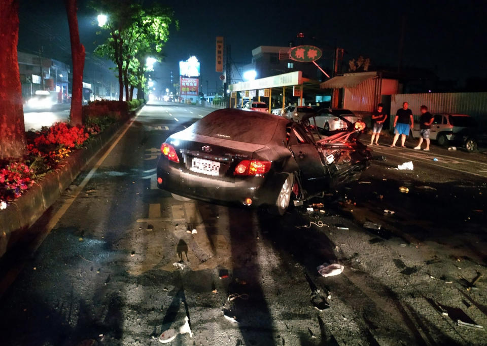 嘉義市北港路19日凌晨發生一起自小客車疑閃車撞擊分隔島起火燃燒，車內一對夫妻被彈出車外，暫無生命危險，車輛零件散落一地。（中央社/嘉義市消防局提供）