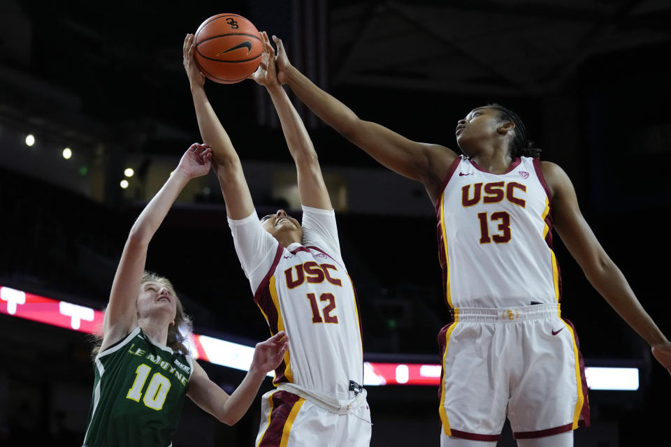 Southern California guard JuJu Watkins (12) and center Rayah Marshall (13) jump up for a rebound against Le Moyne guard Sydney Lusher (10) during the first half of an NCAA college basketball game in Los Angeles, Monday, Nov. 13, 2023. (AP Photo/Ashley Landis)