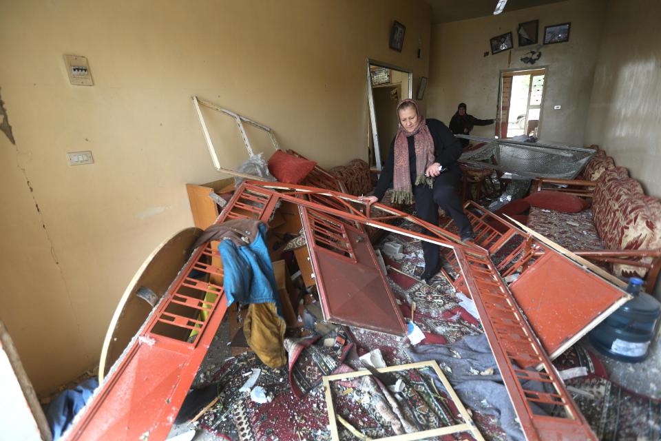 A Lebanese woman steps over debris in a damaged house at the site of a deadly car bomb that exploded Sunday night, in the town of Nabi Othman, about 30 kilometers (18 miles) north of Baalbek, northeast Lebanon, Monday March 17, 2014. Lebanese security officials said the explosion caused panic and massive destruction in the Hezbollah stronghold, which has a sizable Christian population in addition to Shiites. The civil war in neighboring Syria already has ignited polarizing sectarian tensions between Lebanon's Sunnis and Shiites. (AP Photo/Hussein Malla)