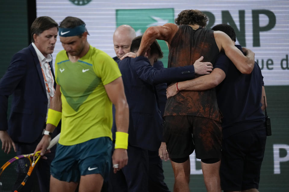 Germany's Alexander Zverev is carried off the court after twisting his ankle during the semifinal match against Spain's Rafael Nadal, left, at the French Open tennis tournament in Roland Garros stadium in Paris, France, Friday, June 3, 2022. (AP Photo/Christophe Ena)