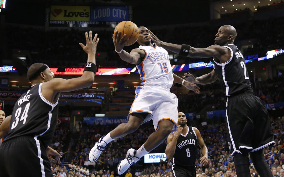 Oklahoma City Thunder guard Reggie Jackson (15) goes up for a shot between Brooklyn Nets forward Paul Pierce (34) and center Kevin Garnett (2) in the fourth quarter of an NBA basketball game in Oklahoma City, Thursday, Jan. 2, 2014. Oklahoma City won 95-93. (AP Photo/Sue Ogrocki)