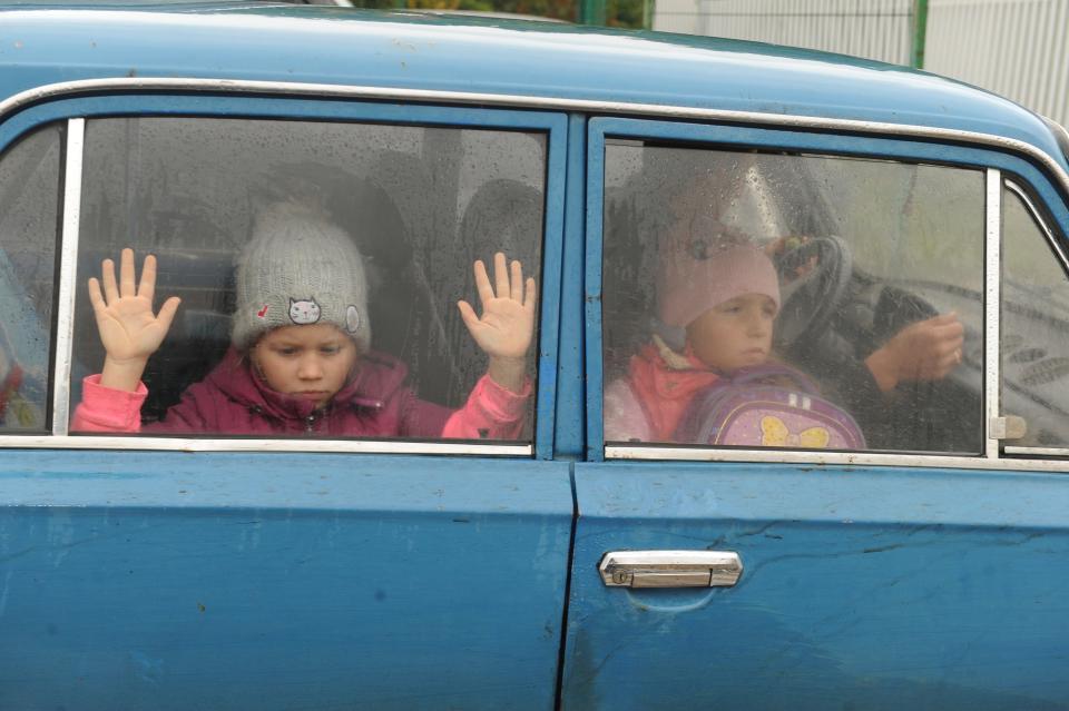 Children look through a car window as they and other refugees from the Kharkiv Region of Ukraine come to a temporary camp in Belgorod, Russia, Wednesday, Sept. 14, 2022. Thousands fled northeastern Ukraine to Russia amid the Ukrainian counteroffensive in the region.