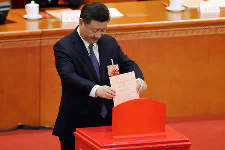 Chinese President Xi Jinping drops his ballot during a vote on a constitutional amendment lifting presidential term limits, at the third plenary session of the National People's Congress (NPC) at the Great Hall of the People in Beijing, China March 11, 2018. REUTERS/Jason Lee