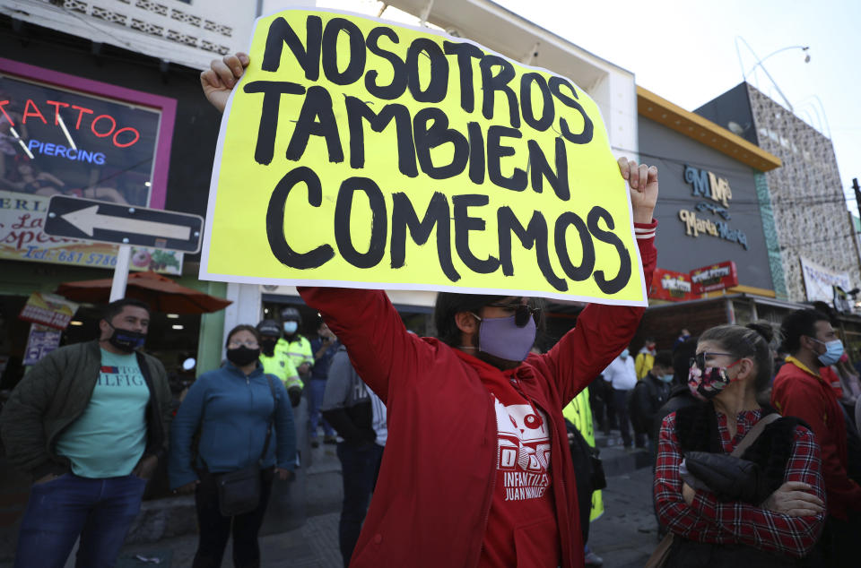 Un hombre sostiene un cartel durante una protesta para exigir el derecho a trabajar durante una cuarentena para evitar más contagios del nuevo coronavirus en Bogotá, Colombia, el viernes 29 de enero de 2021. (AP Foto/Fernando Vergara)