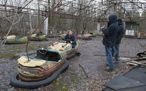 Tourists on a tour of Pripyat Thrill-seeking tourists visit site of Chernobyl disaster, Pripyat, Ukraine  - Credit: Lynn Hilton/Shutterstock