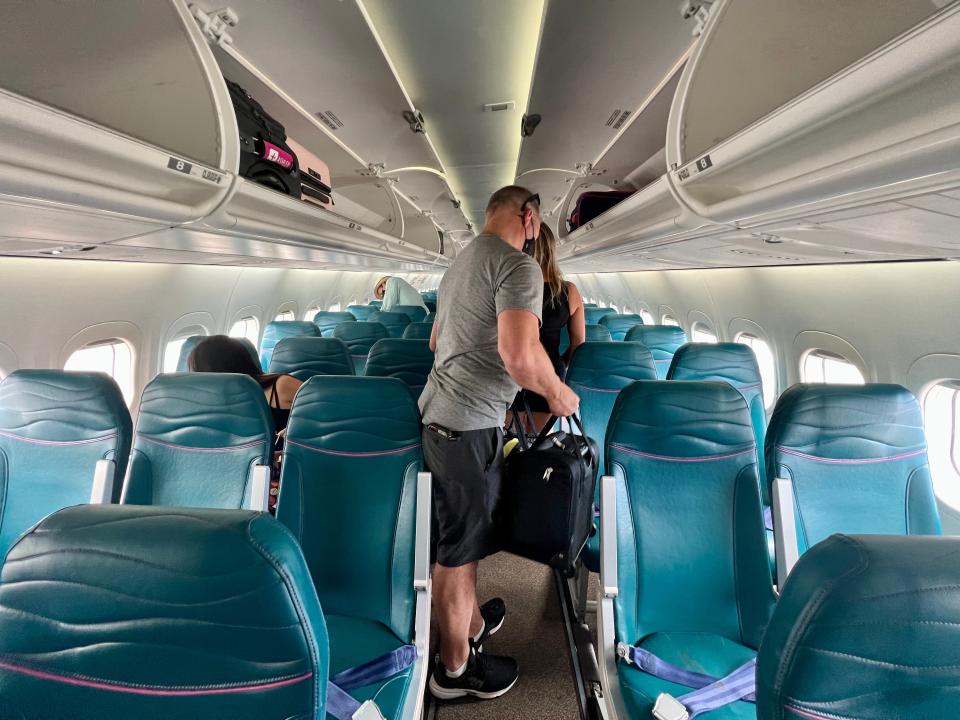 interior of hawaiian airlines pane, blue seats with row of three, aisle, row of two