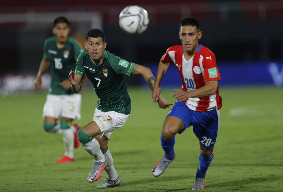 Bolivia's Juan Carlos Arce, left, and Paraguay's Matias Rojas compete for the ball during a qualifying soccer match for the FIFA World Cup Qatar 2022 at the Defensores del Chaco stadium, in Asuncion, Paraguay, Tuesday, Nov. 17, 2020. (AP Photo/Jorge Saenz)