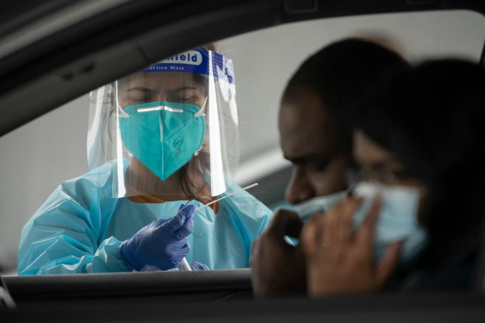 A health worker carries out a COVID-19 testing at the Merrylands drive-through clinic in Sydney, Australia. 