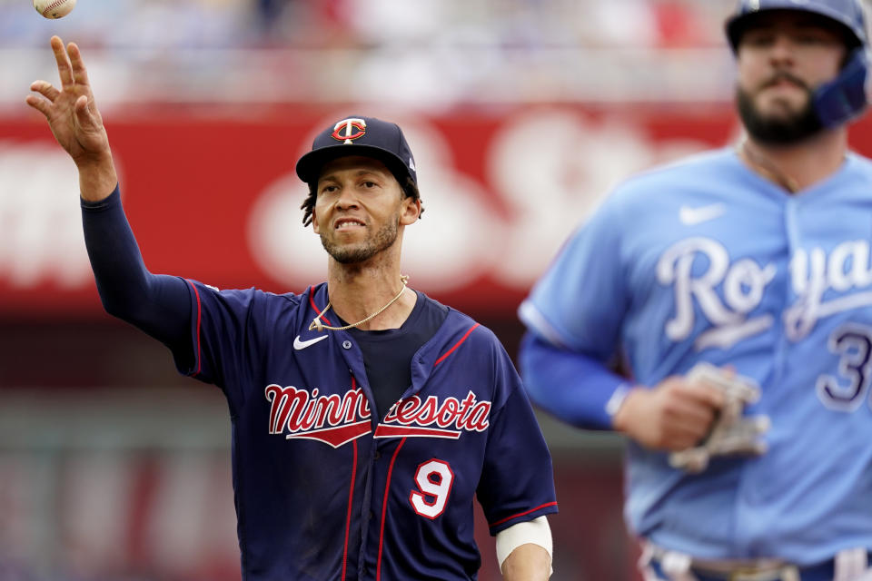 Minnesota Twins shortstop Andrelton Simmons (9) throws to first to get the final out of a triple play on Kansas City Royals' Cam Gallagher, right, during the third inning of a baseball game Sunday, June 6, 2021, in Kansas City, Mo. (AP Photo/Charlie Riedel)