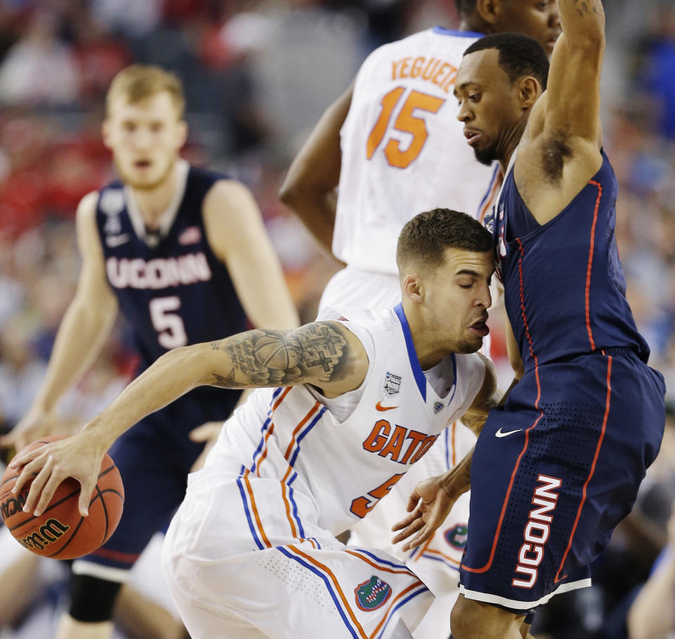 Florida guard Scottie Wilbekin (5) runs into Connecticut guard Ryan Boatright (11) during the first half of the NCAA Final Four tournament college basketball semifinal game Saturday, April 5, 2014, in Arlington, Texas. (AP Photo/David J. Phillip)