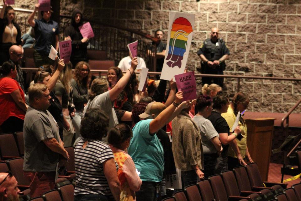 Individuals stand up during the Fowlerville Community Schools Board of Education on Tuesday, July 18, 2023, in support of the LGBTQ+ community and inclusivity.