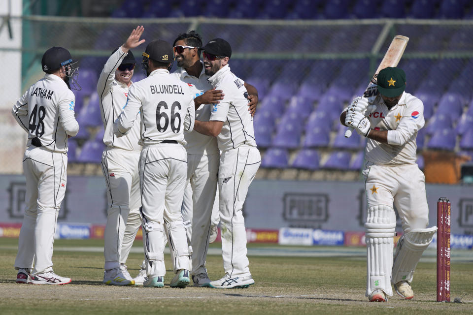Pakistan's Sarfraz Ahmed, right, reacts as New Zealand's Ish Sodhi, center, celebrates with teammates after the Ahmed's dismissal during the fifty day of first test cricket match between Pakistan and New Zealand, in Karachi, Pakistan, Friday, Dec. 30, 2022. (AP Photo/Fareed Khan)