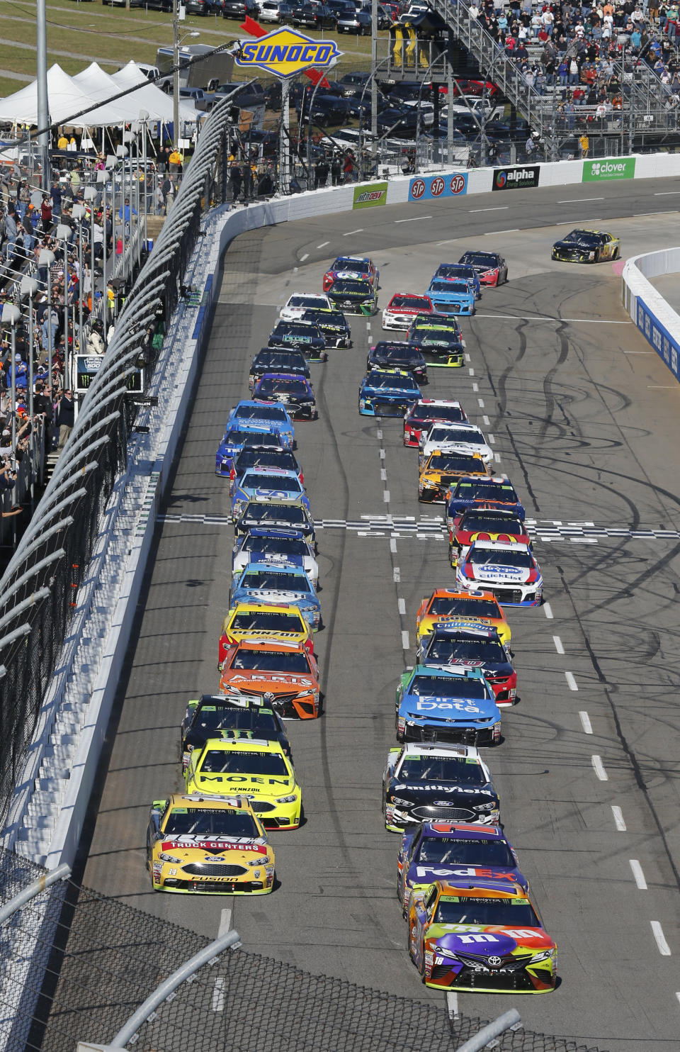 Kyle Busch (18) and Clint Bowyer (14) lead the field at the start of the Monster Energy NASCAR Cup Series auto race at Martinsville Speedway in Martinsville, Va., Sunday, Oct. 28, 2018. (AP Photo/Steve Helber)