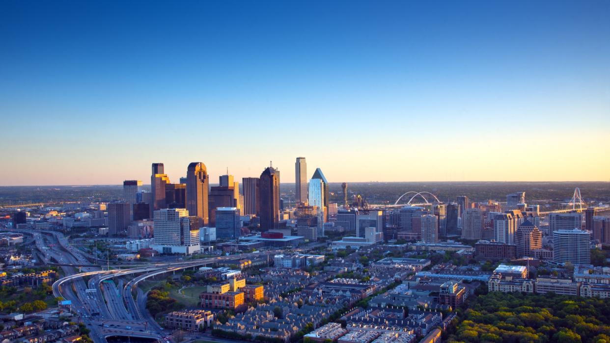  The Dallas skyline is a colorful landscape in late afternoon light. Interstates 45 and 35 converge in a orderly design. 