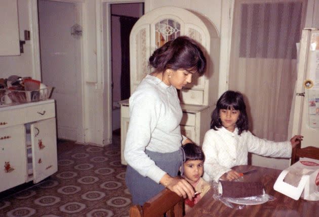 The author with her mom and younger brother as they prepared to cut a birthday cake in their haunted kitchen. (Photo: Courtesy of Salina Jivani)