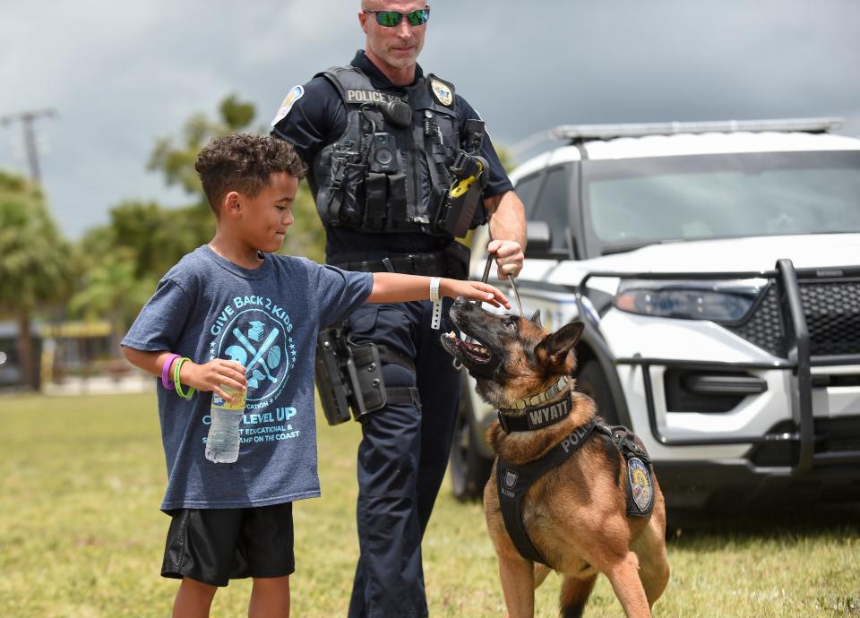 Tresyan Jackson, 6, of Camp Level Up summer sports camp, gets a chance to meet Fort Pierce Police K9 Wyatt, a 3-year-old Belgian Malinois German Shepherd mix, and his handler Officer James Pulliam during the 4th annual Unity in our Community event hosted by the Fort Pierce Police Department at the Fort Pierce Recreation Center on Wednesday, July 6, 2022, in Fort Pierce. "The dog was soft and playful and nice," Tresyan said.