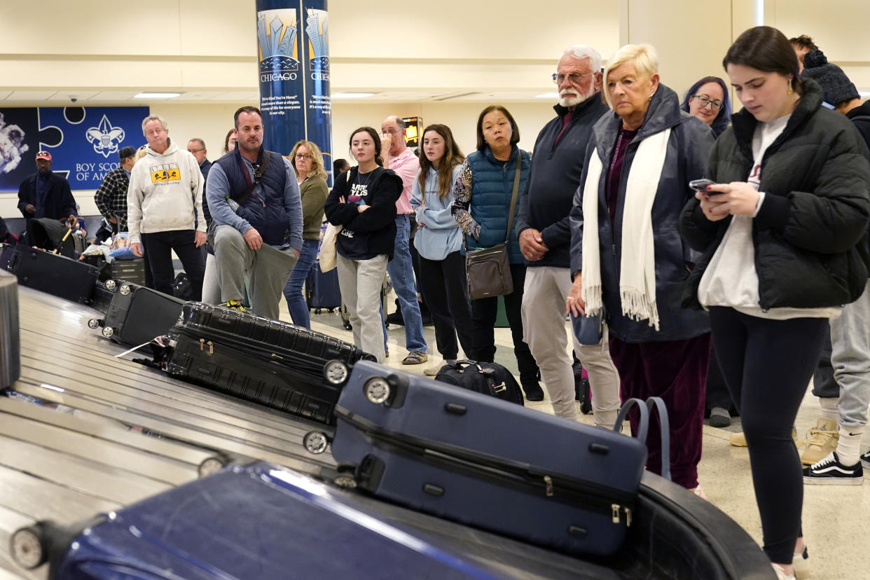 Passengers arriving at Chicago's Midway Airport wait for their luggage just days before a major winter storm Tuesday, Dec. 20, 2022, in Chicago. (AP Photo/Charles Rex Arbogast)