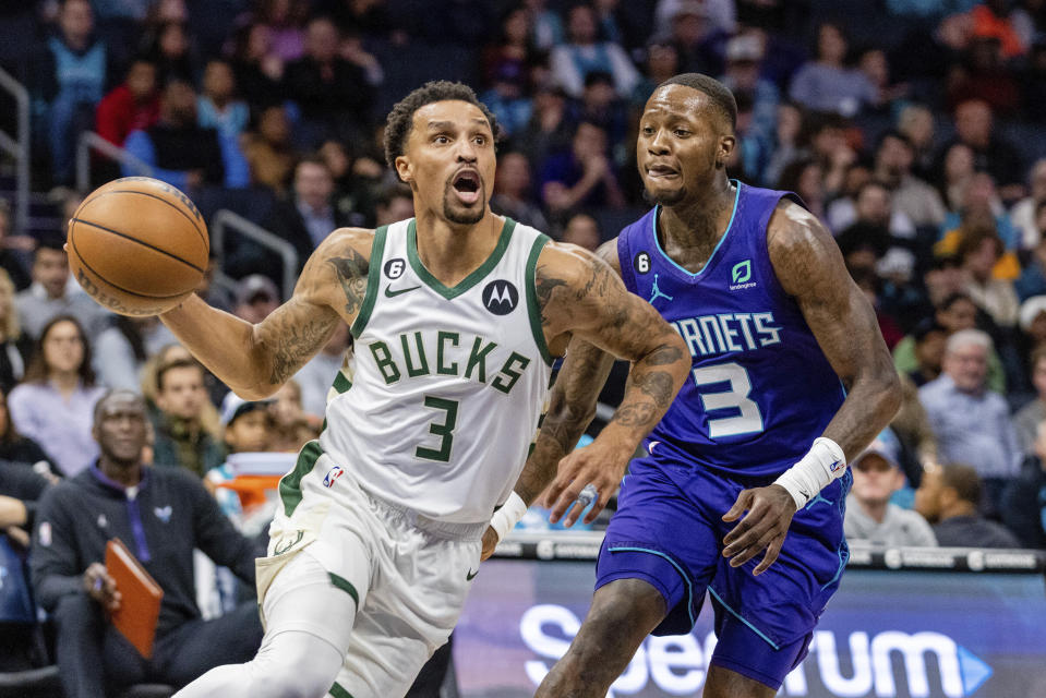 Milwaukee Bucks guard George Hill, left, drives past Charlotte Hornets guard Terry Rozier during the first half of an NBA basketball game Saturday, Dec. 3, 2022, in Charlotte, N.C. (AP Photo/Scott Kinser)