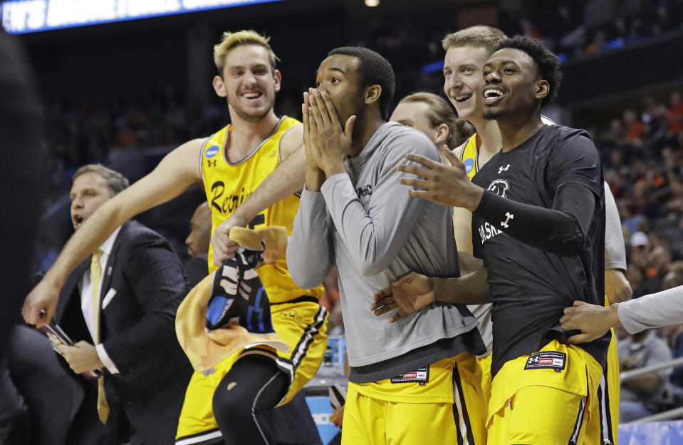 FILE - In this March 16, 2018, file photo, UMBC players celebrate a teammate's basket during the second half against Virginia i a first-round game in the NCAA men's college basketball tournament in Charlotte, N.C. (AP Photo/Gerry Broome, File)