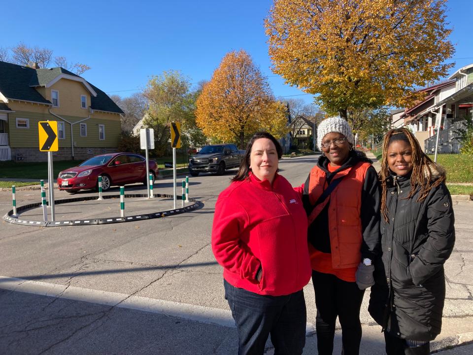 Amber Miller, (l) AARP Wisconsin's associate state director of community outreach, Amani resident Barbara Smith, (c) and Maricha Harris, (r) executive director of the Dominican Center pose in front of a newly installed traffic calming circle on Monday, October, 30 as cars whiz by. A collaborative effort among several community groups and AARP worked to address traffic and pedestrian safety concerns on Locust Street.