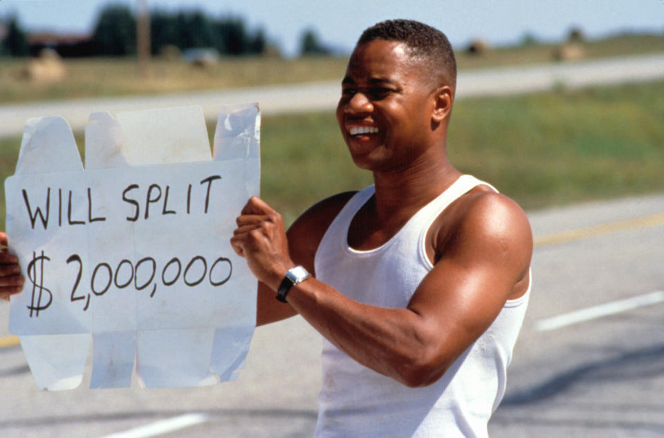 A man holding a sign reading: "Will split $2,000,000"